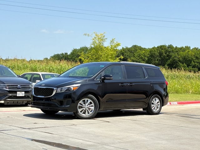 2016 Kia Sedona LX in Aurora Black Pearl — front three-quarter view
